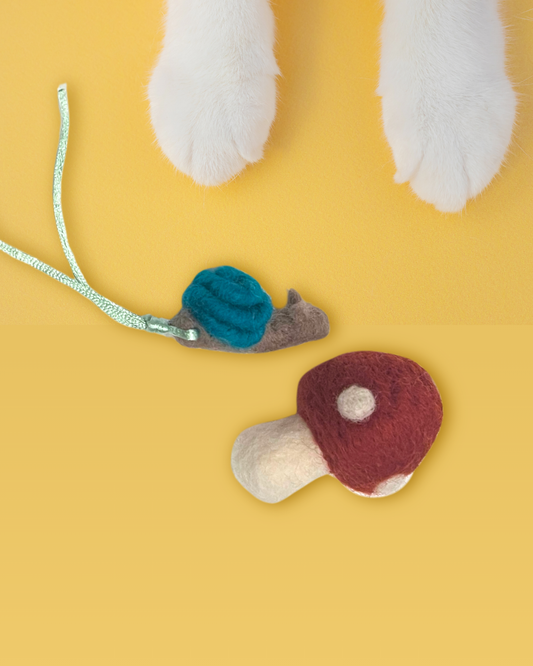 Cat toys resembling mushrooms and a snail on a yellow background